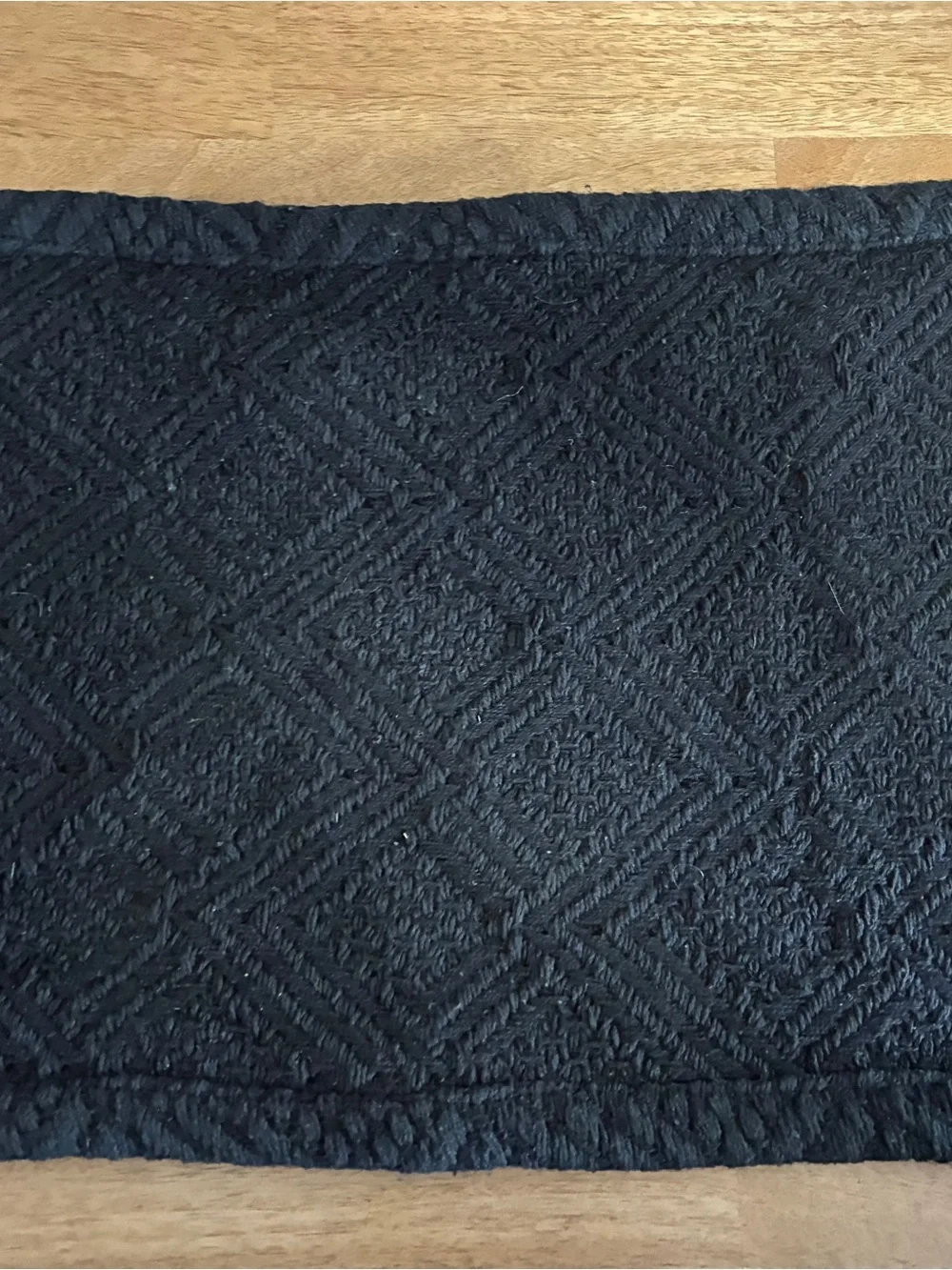 6 black placemats features a woven diamond pattern and decorative fringe edges